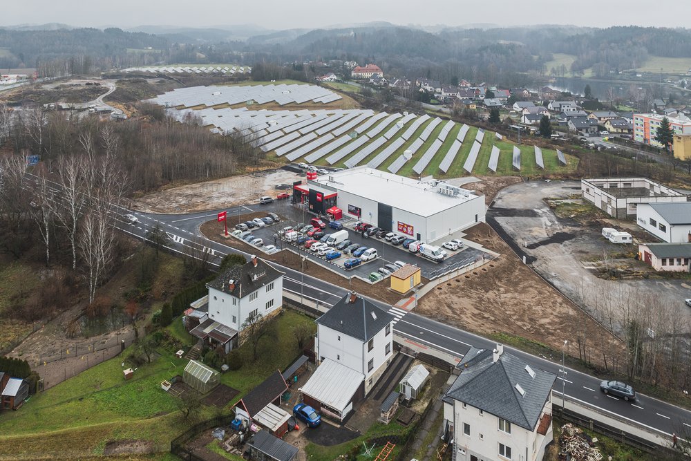 Retail park Lužická z dronu: první etapa s prodejnou Penny, v pozadí solární park
