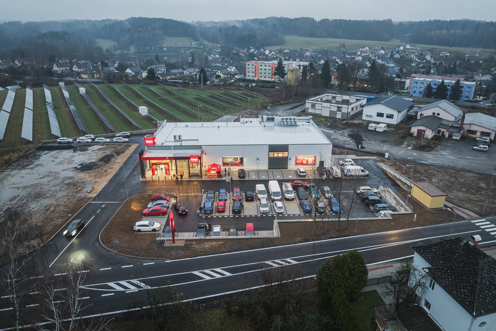 První etapa retail parku Lužická z dronu za soumraku, parkoviště a napojení na silnici